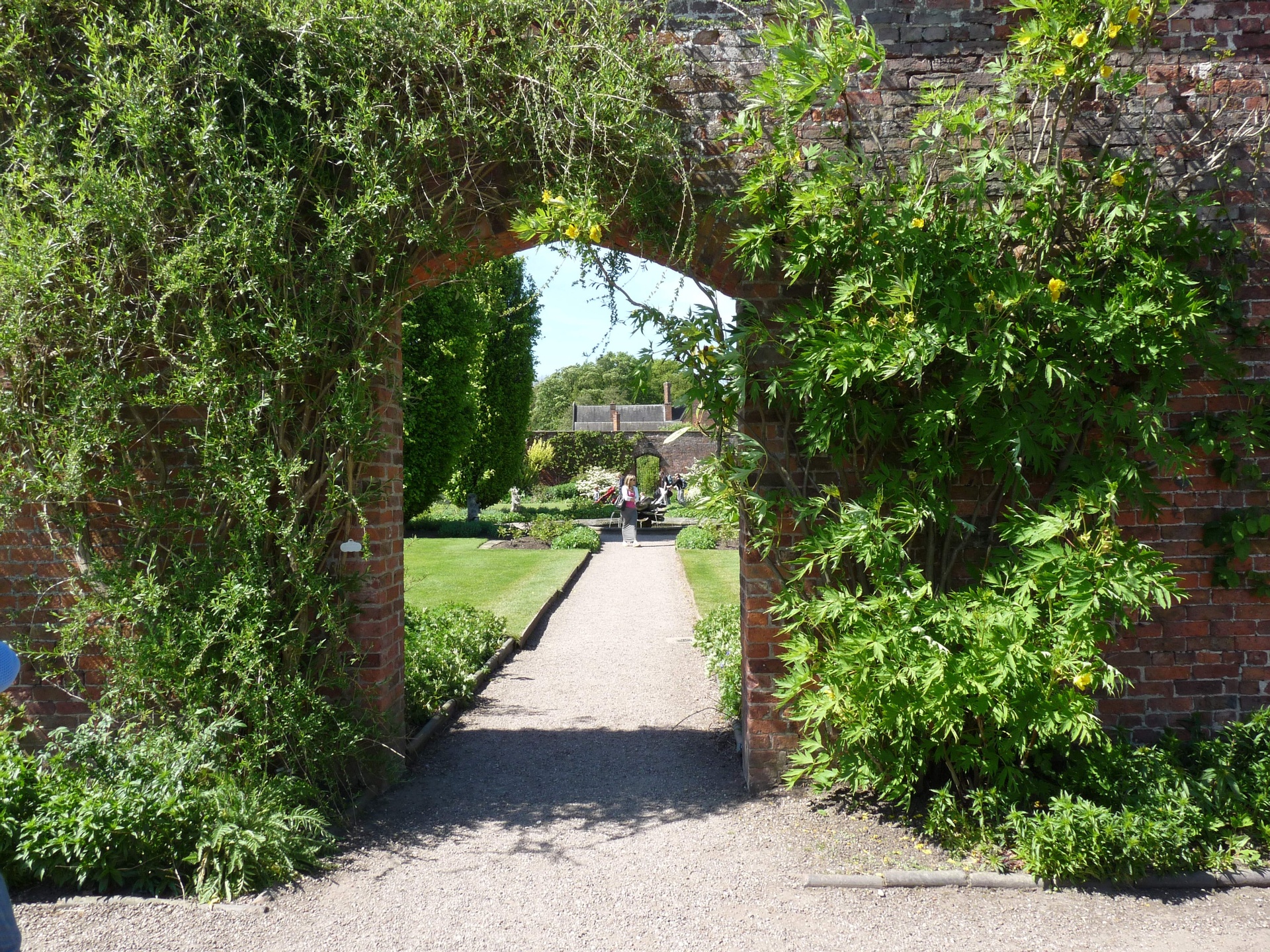 A garden path through a green archway