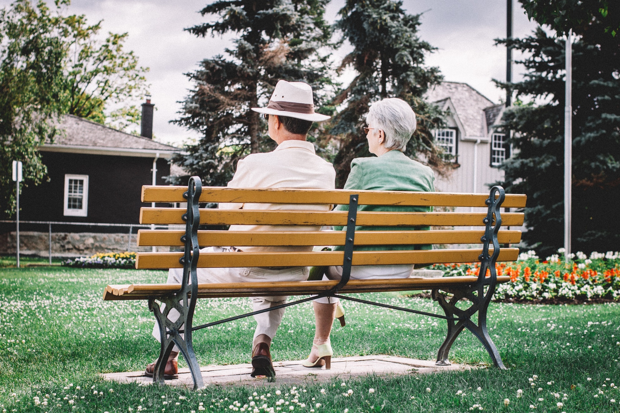 Two older adults sitting together on a bench